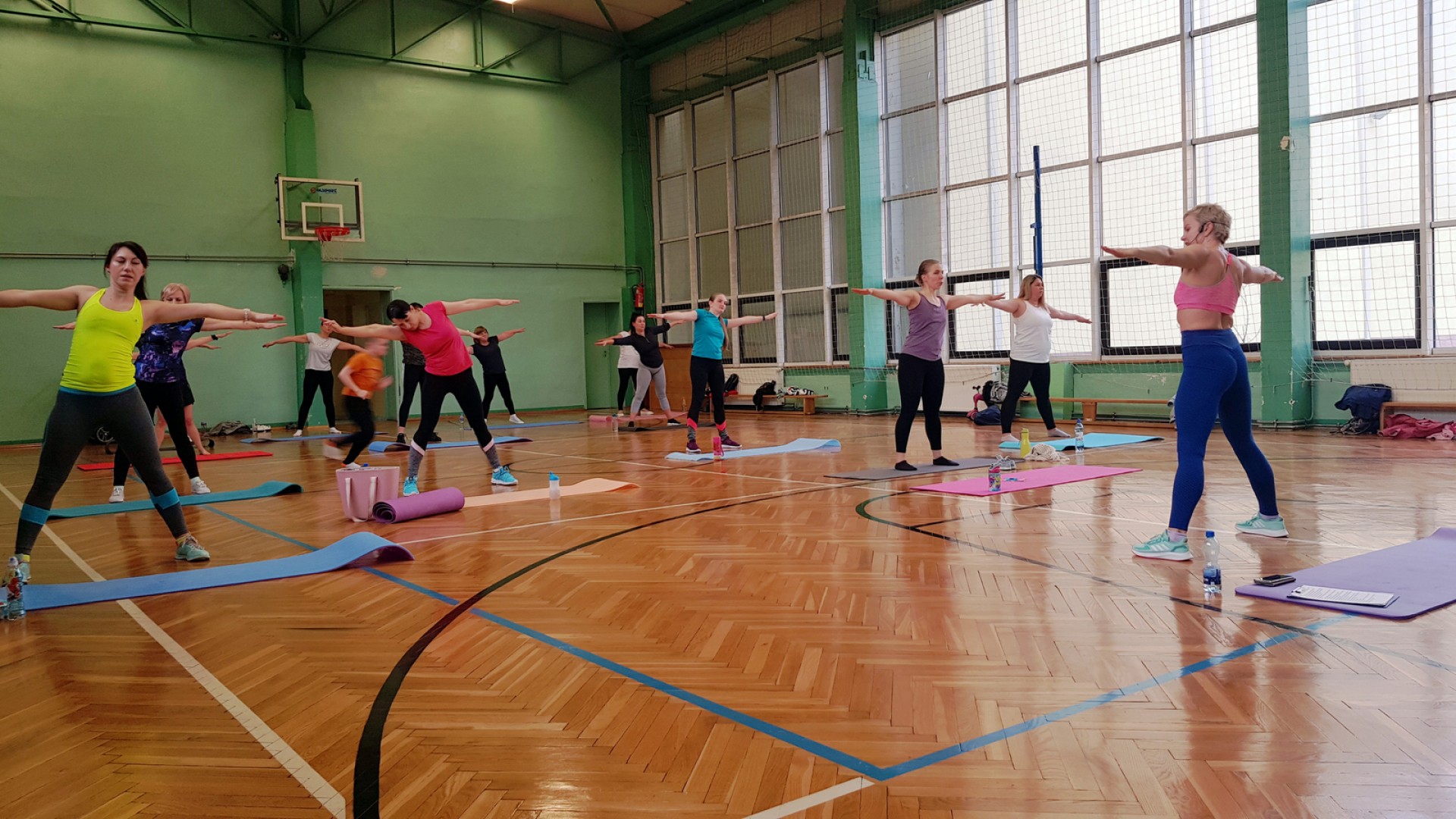 Zdjęcie przedstawiające osoby ćwiczące na sali gimnastycznej.
